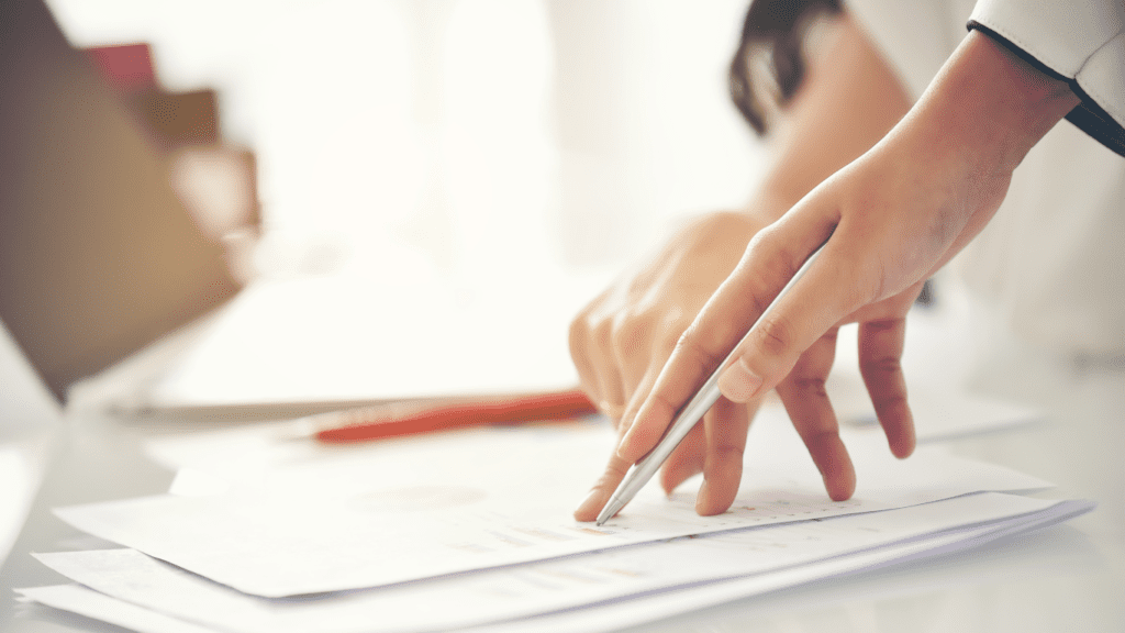 Close up of scientists' hands consulting over paperwork